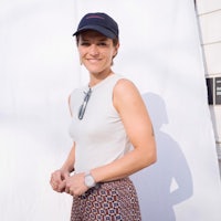 a woman wearing a hat and patterned skirt