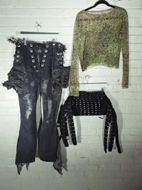 three pieces of clothing hanging on a brick wall