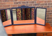 a blue dresser with a mirror on it
