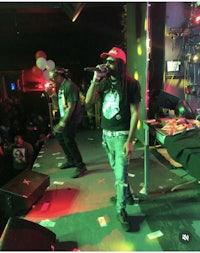 two men standing on stage in front of a crowd
