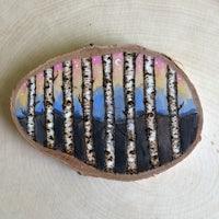 a piece of wood with birch trees painted on it