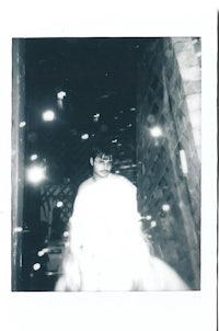 polaroid of a woman riding a horse in a dark room
