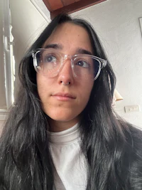 a woman wearing glasses and a white shirt