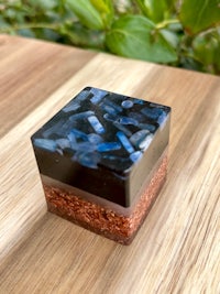 a square box with blue and brown stones on top