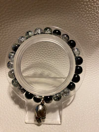 a black and silver bead ring on a white surface