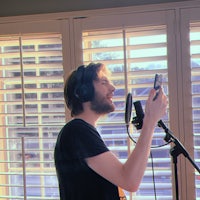 a man holding a cell phone in front of a window