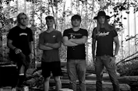 black and white photo of a group of young men standing in a wooded area
