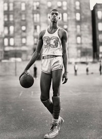 a black and white photo of a basketball player holding a ball