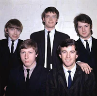 a group of young men in suits posing for a photo