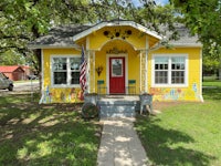 a yellow house with an american flag painted on it