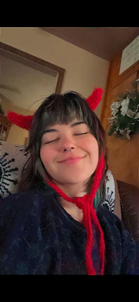 a woman wearing a knitted devil horn hat