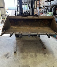 a forklift with a bucket sitting in a garage