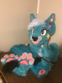 a blue stuffed animal sitting on a desk