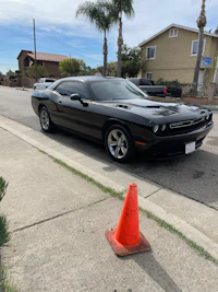 a black car parked next to an orange cone