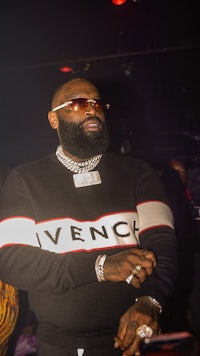 a man with a beard and sunglasses standing in front of a crowd