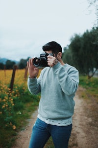a man taking a picture with a camera in a field