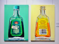 two paintings of bottles with labels on them