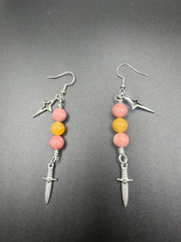 a pair of earrings with a yellow and pink bead on them