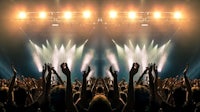 a crowd of people raising their hands at a concert