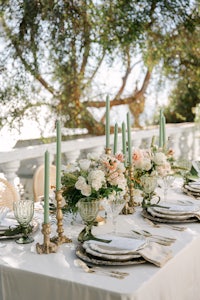 a table set with green and gold plates and silverware