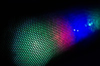 a close up of a colorful light on a black background