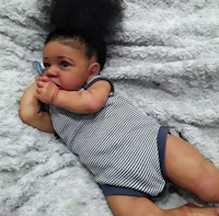 a baby laying on a blanket with an afro