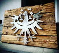 a metal eagle on a piece of wood