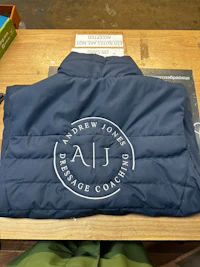 a blue jacket with a logo on it sitting on a table
