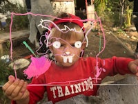 a young boy holding up a drawing of a cat