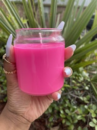 a person holding a pink candle in their hand