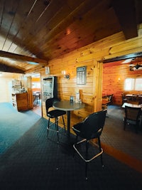 a room in a log cabin with a table and chairs
