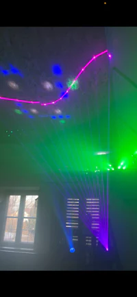 a room with a green, blue, and purple light projector