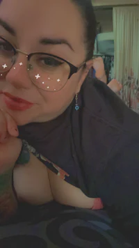 a woman with glasses laying on a bed