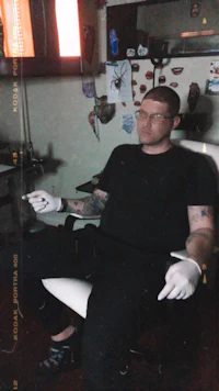 a man sitting in a chair with a tattoo on his arm