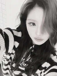 a black and white photo of a woman wearing a striped sweater