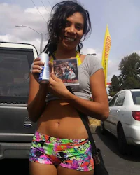 a girl in colorful shorts holding a bottle of beer