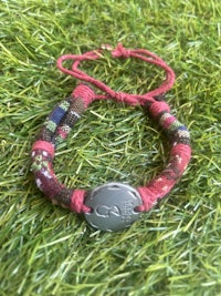 a red bracelet with a silver charm on it