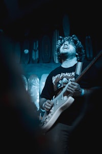 a man playing a guitar in a dark room