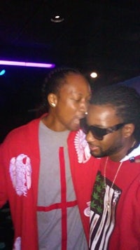 two men standing next to each other at a nightclub
