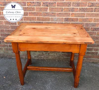a small wooden table with a logo on it