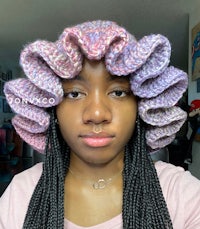 a woman wearing a crocheted ruffled hat