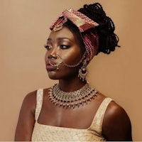 an african woman wearing a necklace and earrings