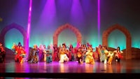 a group of people in colorful costumes on stage