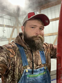 a bearded man wearing overalls and a beard