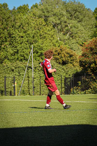 a man kicking a soccer ball in a field