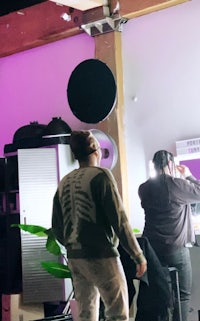 a group of people standing in a room with purple lights