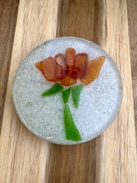 a piece of glass with a flower on it