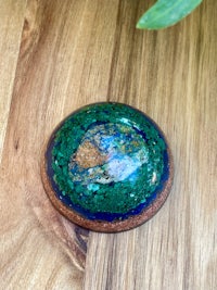a green and blue stone on top of a wooden table