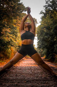 a woman doing yoga on a train track
