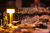 a wooden shelf with wine glasses and plates on it